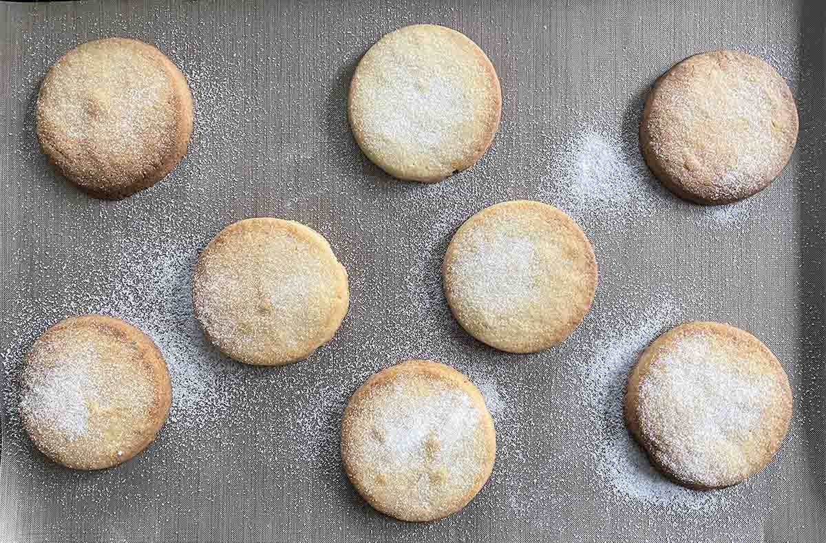 biscuits dusted with sugar on a baking tray.