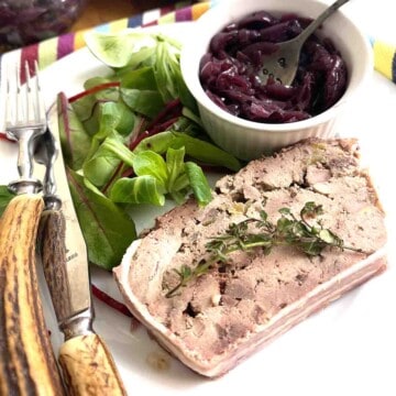 slice of game terrine on a plate with salad and chutney.
