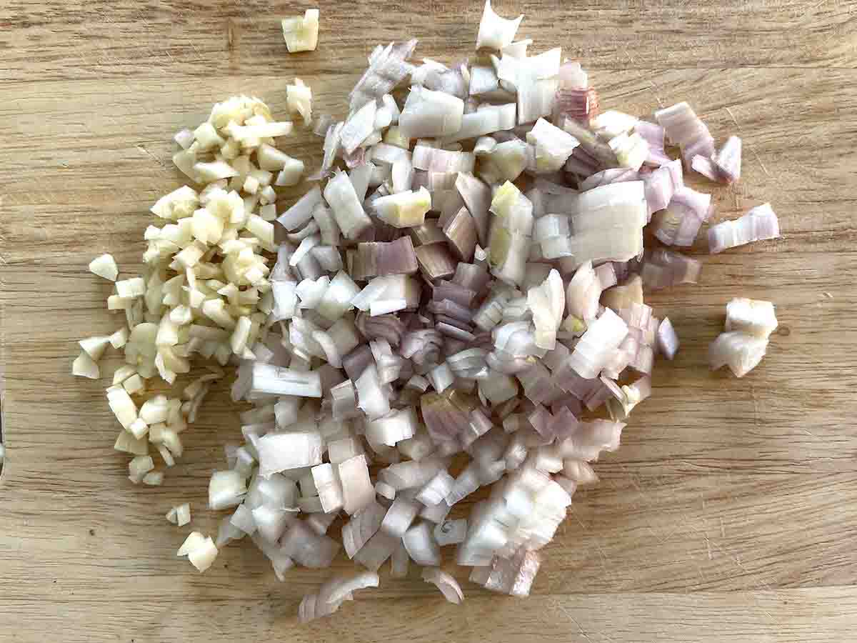 chopped shallots and garlic on a board.