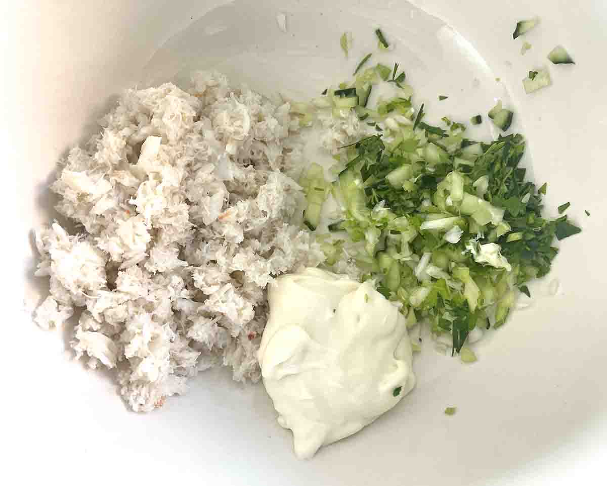 crab, mayonnaise and herbs in a bowl.