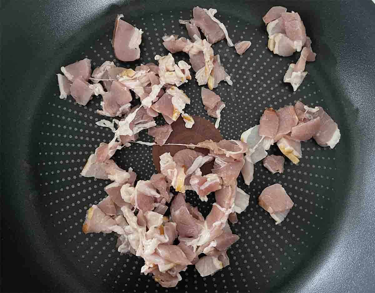 chopped bacon in a frying pan.