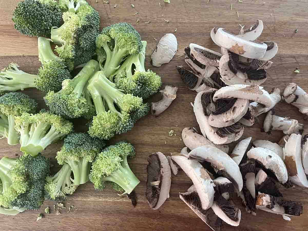 cut broccoli and mushrooms on a board.