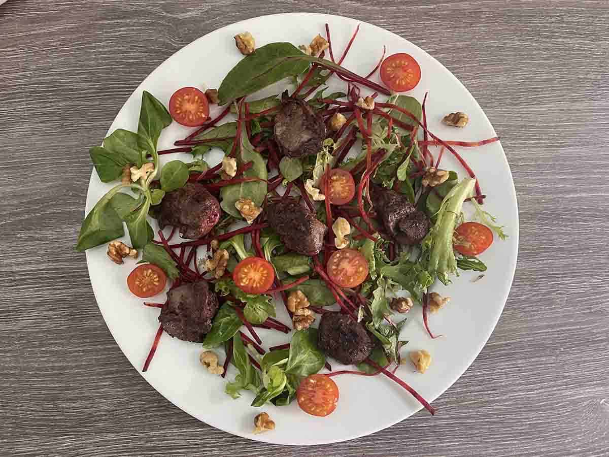 salad with tomatoes, walnuts and dressing added.