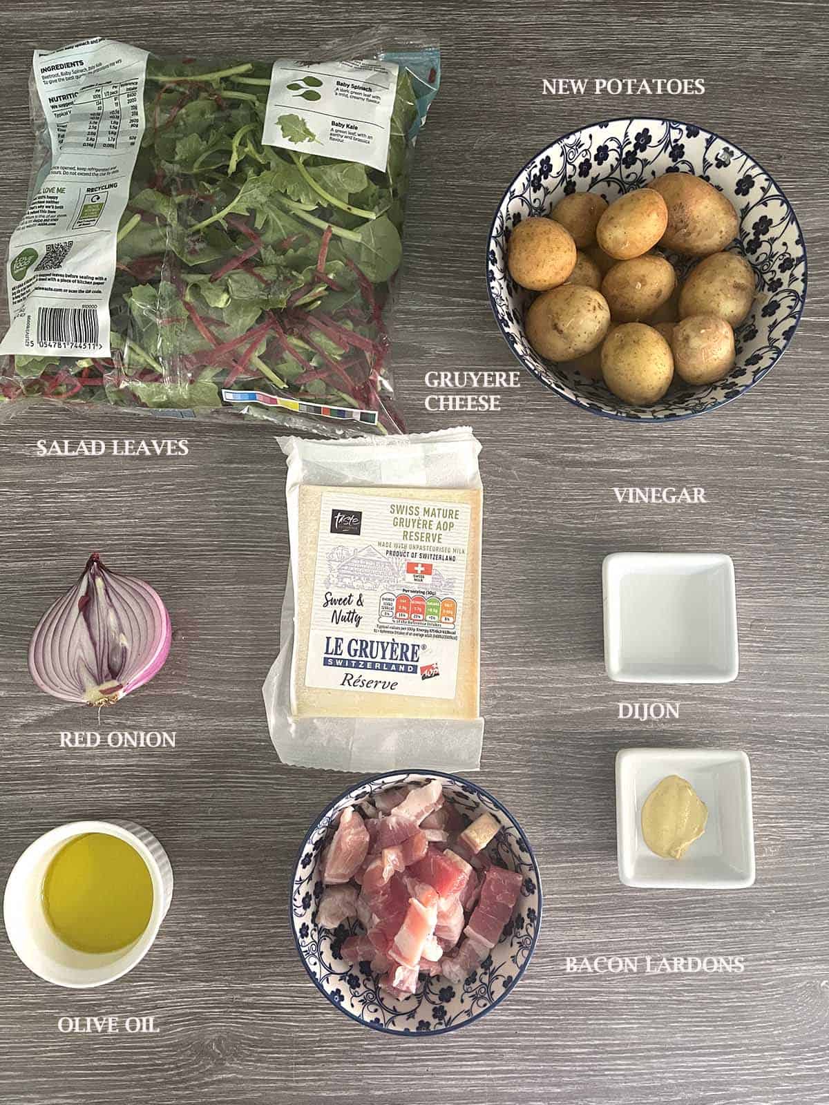 ingredients including cheese, salad leaves, bacon and new potatoes.