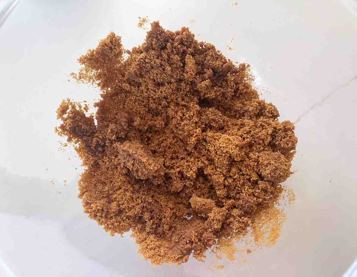 crushed biscuits in a bowl mixed with butter.