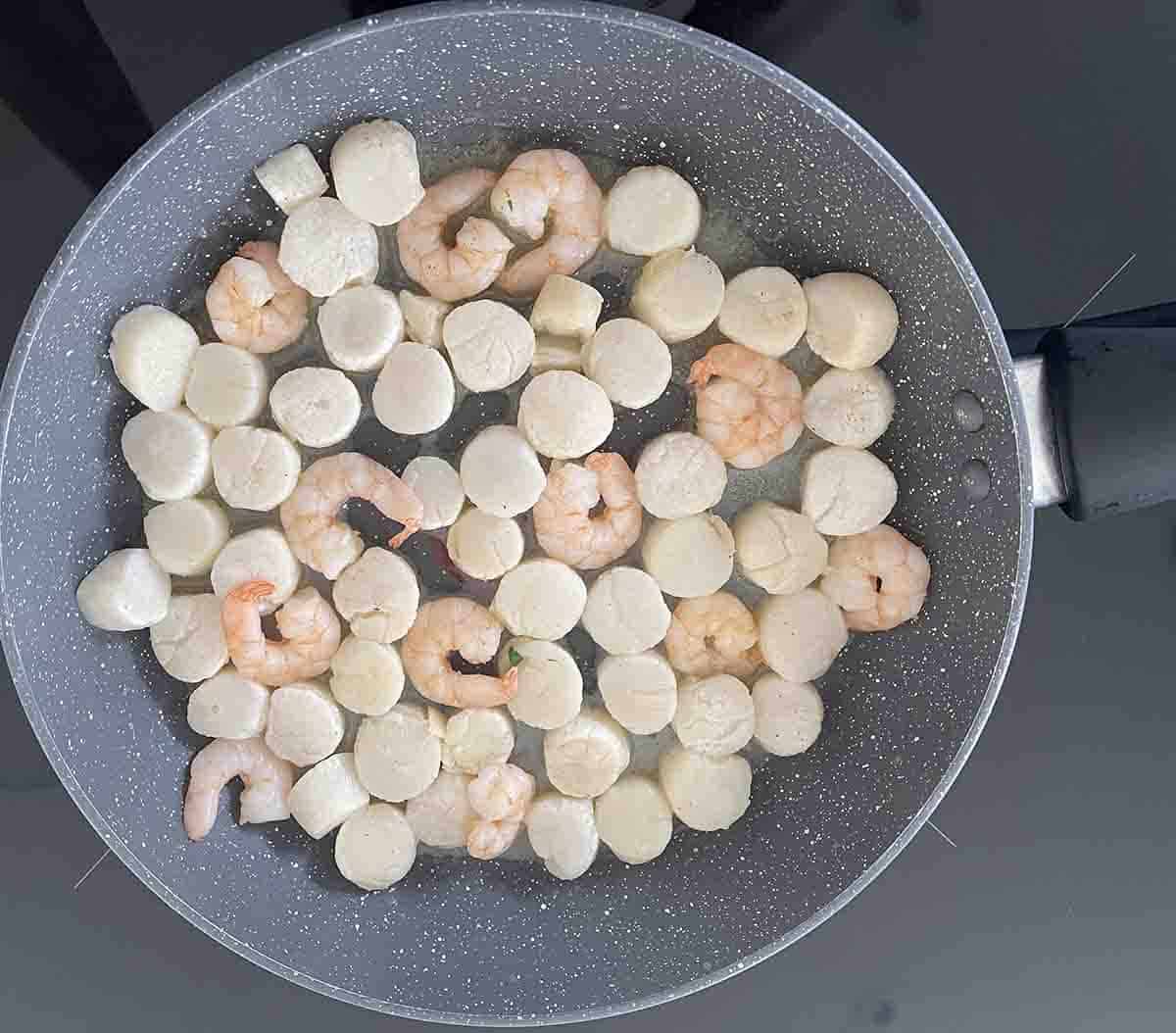 scallops cooking in a pan.