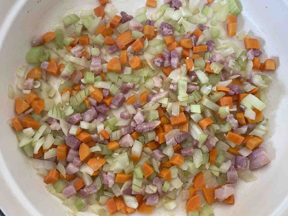 chopped vegetables added to bacon.