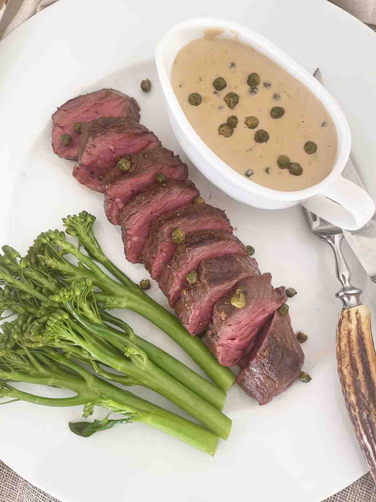 sliced onglet with peppercorn sauce.