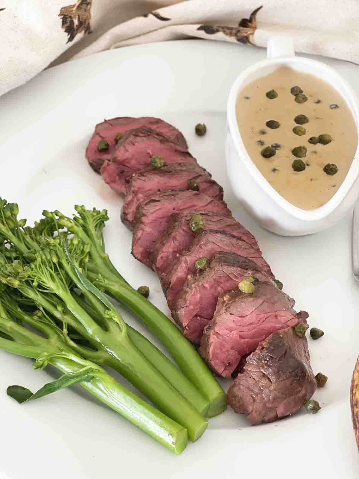sliced onglet with peppercorn sauce.